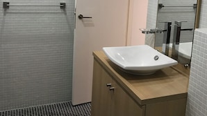A bathroom with a white sink, wooden vanity, and a mirror. - Rented T2 independent shared pool at home Near beaches. (Perpignan)