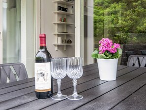 A bottle of wine, two glasses, and a potted plant on a table. - 4 Person Holiday Home in Ringkobing (Ringkobing)