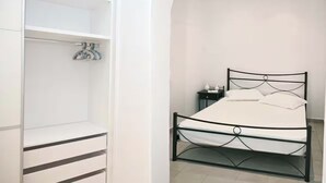 A bedroom with a bed, a wardrobe, and a nightstand.