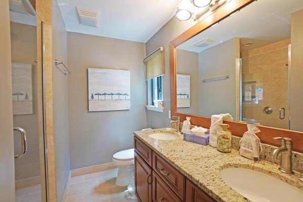 A bathroom with a granite countertop, a large mirror, a toilet, and a shower area. - Shady Pines - Sea Pines 8 Wildwood Ct 4 Bedroom Home (Hilton Head Island)
