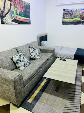 Comfort-værelse til 3 personer - byudsigt | Opholdsområde | 10-tommers LCD-tv med satellitkanaler