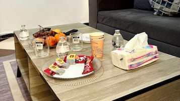 Luxe driepersoonskamer, kitchenette | Woonruimte | Een 10-inch lcd-televisie met satellietzenders