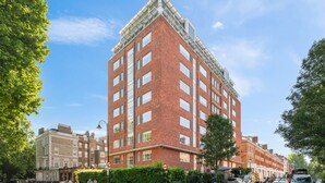 A multi-story red brick building with a corner entrance, large windows, and a flat roof. - Roland House - Deluxe Studio D (London)