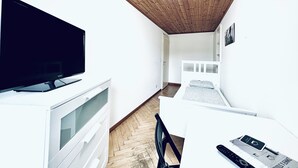 A small, modern room with a wooden ceiling, a bed, a desk with a computer, and a TV. - ZIMMERzuVERMIETEN.ch Flumenthal SO (Flumenthal)