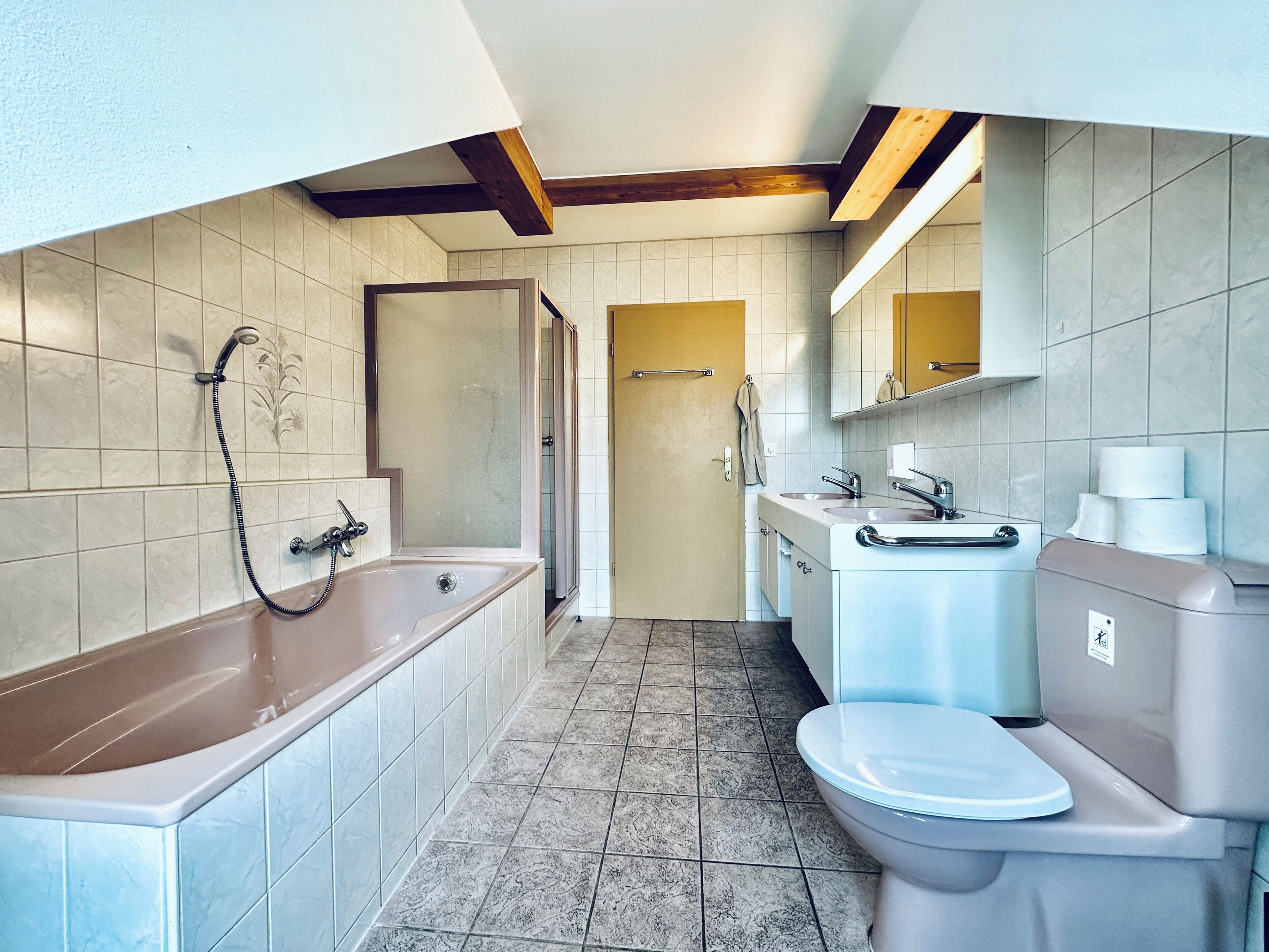 A modern bathroom with a bathtub, toilet, and sink.