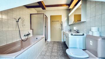 A modern bathroom with a bathtub, toilet, and sink.