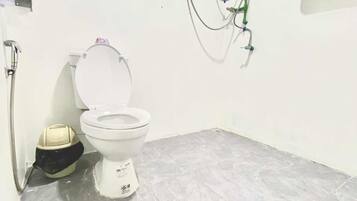 A small bathroom with a toilet, a shower, and a sink.
