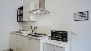 A compact kitchen with a gas stove, a toaster oven, and a microwave. - Oceano & Mare Apartments  (Trapani)