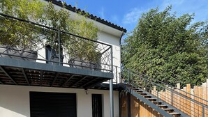 A modern building with a covered outdoor area, a staircase, and a gravel driveway. - Studio rental (minimum 2 nights). (Béziers)