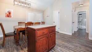 A spacious dining area with a wooden table and chairs, a built-in wooden cabinet, and a ceiling fan. - Welcome to Mountain Getaway in this cozy 4 bed 3 bath home. (Idaho Falls)