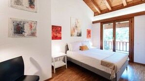 Una camera da letto con un letto, una sedia e opere d'arte alle pareti.