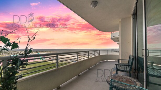 A balcony with a view of the beach and a sunset. - Ocean Club 408 | Enjoy Views of the Gulf! (Biloxi)