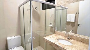 A modern bathroom with a glass-enclosed shower, a white toilet, and a marble sink with a large mirror. - Arrey Express Hotel - Picos (Picos)