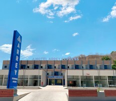 Un hotel moderno con un cartel azul llamativo y un cielo despejado.