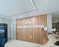 Un moderno vestíbulo de hotel con un mostrador de recepción de madera, un minibar y un separador de vidrio.