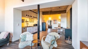Interior moderno com cozinha, sala de jantar e área de estar.