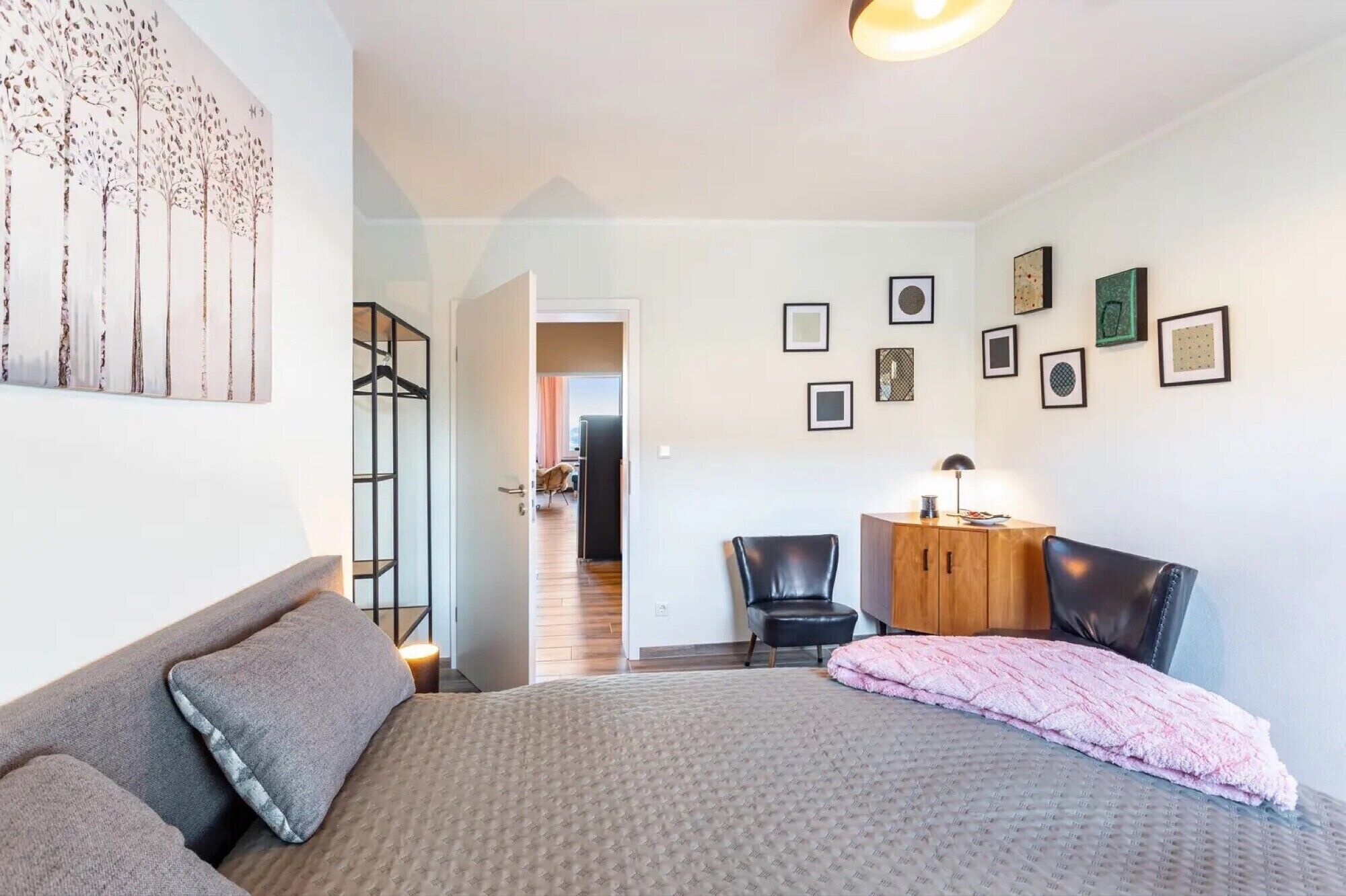 Ein Schlafzimmer mit Bett, Schreibtisch, Stuhl und Kleiderschrank.
