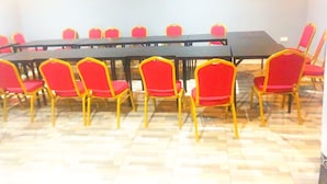 A conference room with a long table and red chairs with gold frames. - Immaculate 10-bed Lodge in Kigali (Kigali)