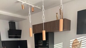 A modern kitchen with a central island, black chairs, and a vase with flowers. - Apartment for rent - Cap d'Agde, plage Richelieu Sea view - Quiet - Comfort - (CAP D'AGDE)