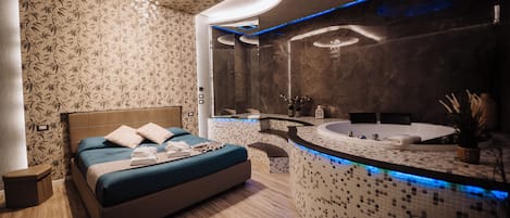 A modern bedroom with a large bed, a built-in bathtub, and a vanity with a mirror.