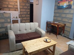 Appartamento Deluxe, vista città | Area soggiorno | Smart TV 34 pollici con canali digitali