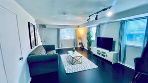 Ein modernes Wohnzimmer mit einer Couch, einem Couchtisch und einem Fernseher.
