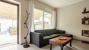 Ein Wohnzimmer mit Sofa, Couchtisch, Stehlampe und Bücherregal.