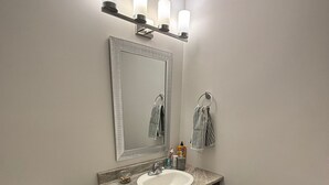 Ein Badezimmer mit Toilette, Waschbecken, Spiegel und Handtuchhalter.