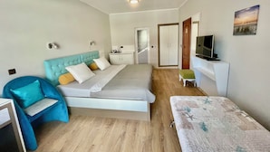 A bedroom with a bed, a chair, a desk, a television, and a wardrobe. - Elegant bed & breakfast in wonderful Burgas with WiFi, AC (Burgas)