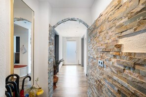 A hallway with stone walls, a wooden floor, and a door at the end. - Apartment 'Dina' with Private Terrace, Balcony, and Wi-Fi (Haslach im Kinzigtal)