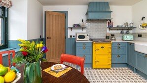 A kitchen with blue cabinets, a yellow stove, and a white microwave. - Luxury rural escape in peaceful Aberdeenshire (Alford)