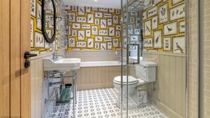 A bathroom with a shower, toilet, sink, and a wall decorated with framed bird and plant illustrations. - Luxury rural escape in peaceful Aberdeenshire (Alford)