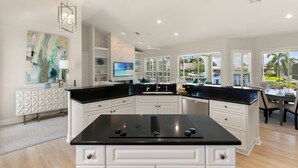 Una cocina moderna con armarios blancos, encimera negra y una isla grande.