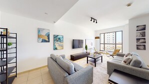A modern living room with two sofas, a coffee table, a TV, and artwork on the walls.