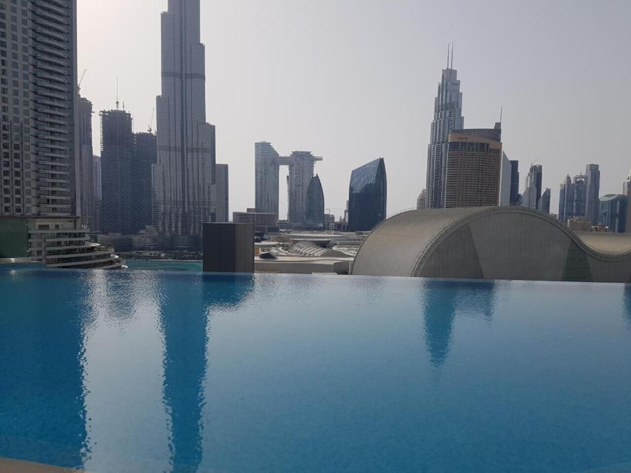 Une piscine sur le toit, avec la silhouette de la ville en arrière-plan.