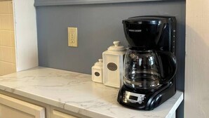 A kitchen with a marble countertop, a black coffee maker, and white cabinets. - My Sisters Place | Sleeps 6 • Piano & Pool Table (Concord)