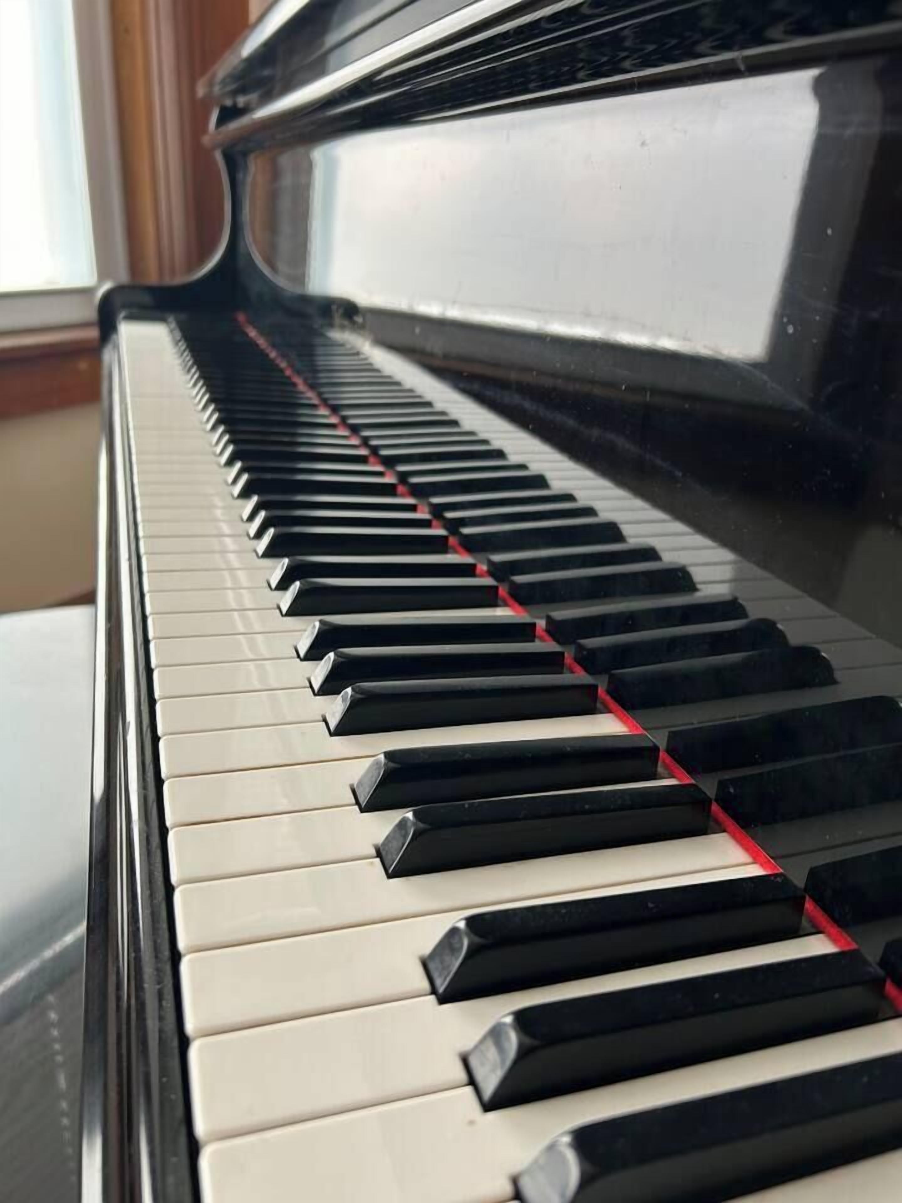 Eine Nahaufnahme einer Klaviertastatur mit schwarzen und weißen Tasten.