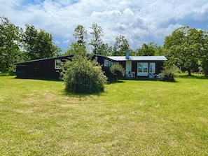 Une maison à deux étages avec un porche et une pelouse devant.