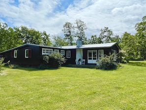 Une maison à deux étages avec un porche et une pelouse devant.