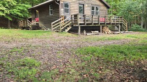 A rustic cabin with a wooden deck and stairs leading to a porch. - Waterfront cabin on Long Lake. (New Auburn)