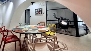 Ein modernes Interieur mit einem runden Tisch, Stühlen und einer Glastrennwand.