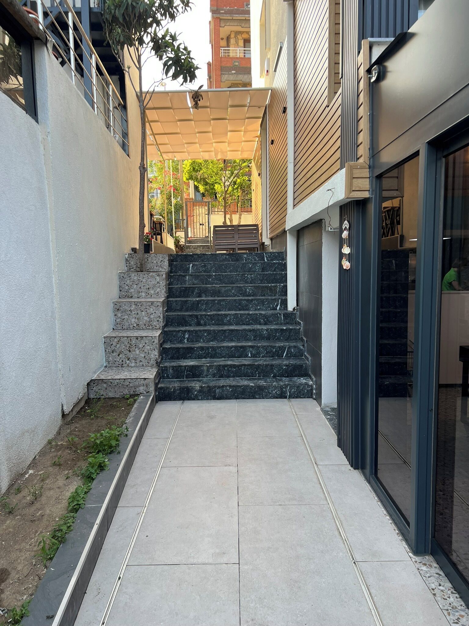 Ein modernes Gebäude mit einer Treppe, die zu einem überdachten Eingang führt.