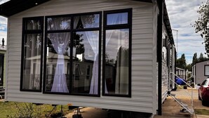 Una casa móvil con un ventanal grande y techo negro.