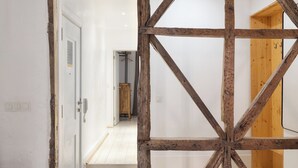 Ein Korridor mit Holzbalken, einer weißen Tür und einem Holzschrank.
