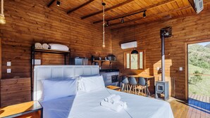 L’intérieur d’un chalet en bois comprend un lit, un coin cuisine et un espace repas.