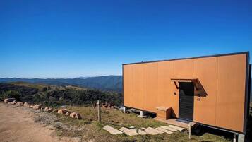 A modern, single-story building with a flat roof, a door, and a small porch area.