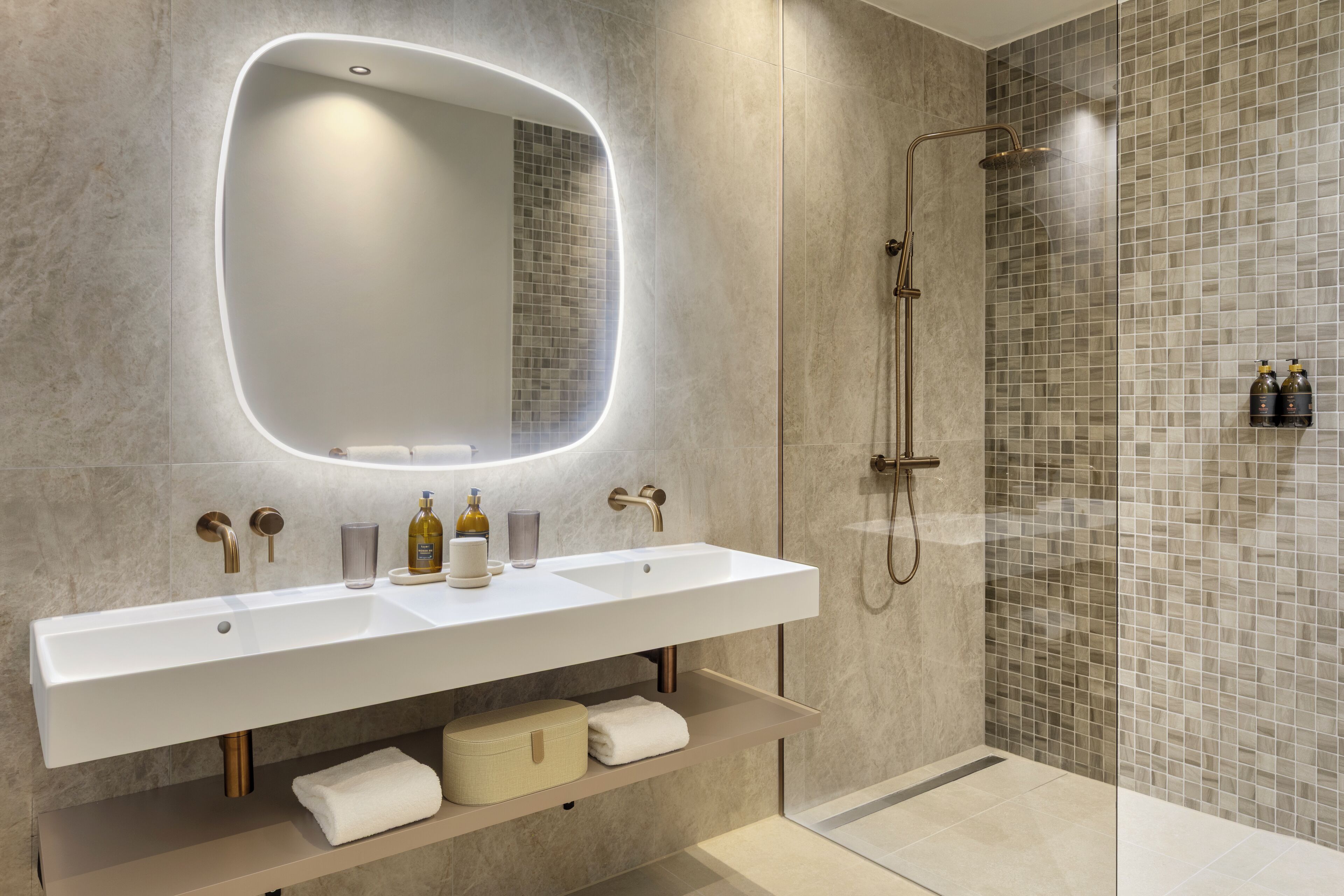 Un baño moderno con un espejo grande, dos lavamanos y una ducha.
