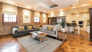 Un espacio habitable amplio con un conjunto de sofás, una mesa de centro y una zona de comedor con sillas.