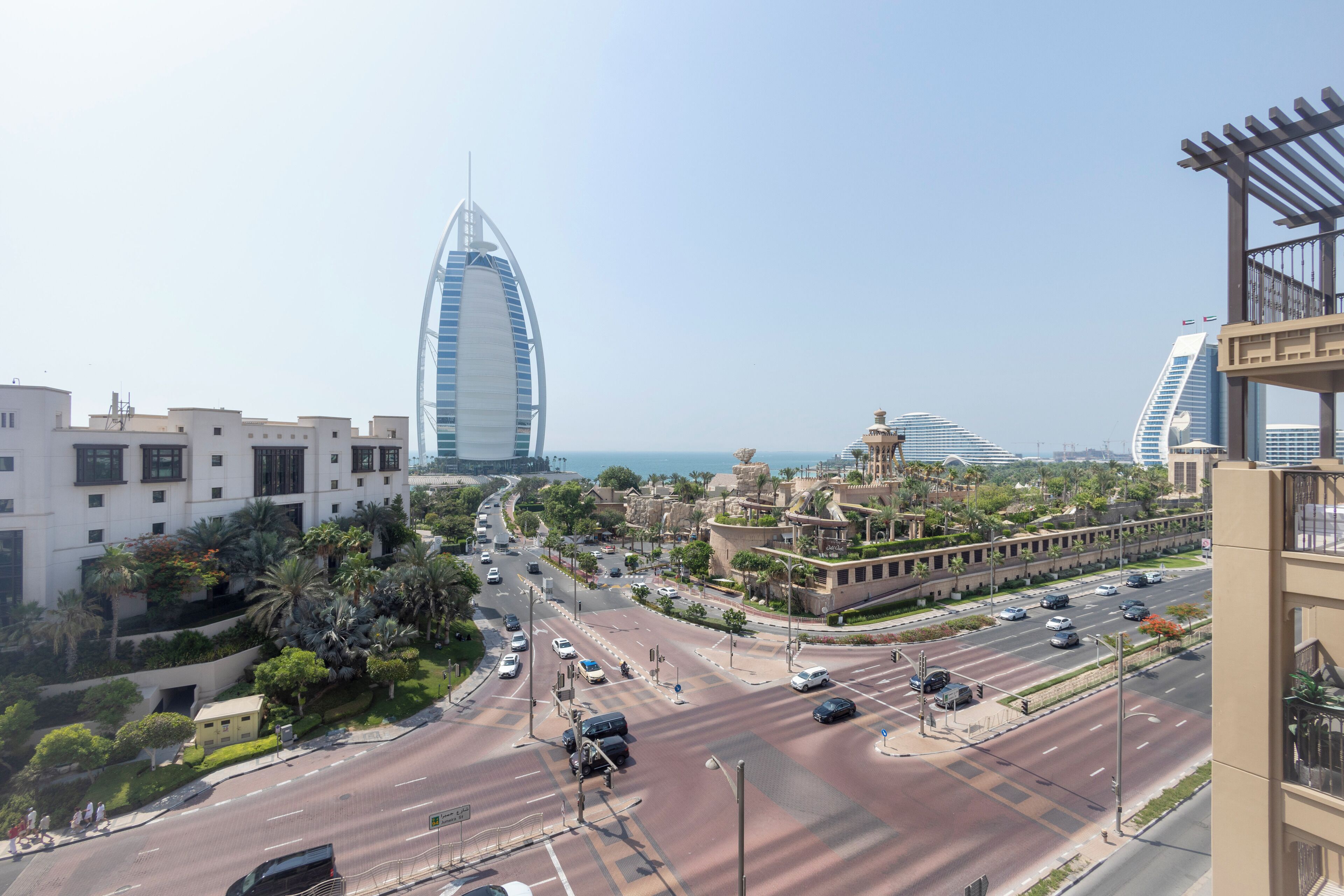 A cityscape with a prominent modern building, a busy intersection, and surrounding greenery.