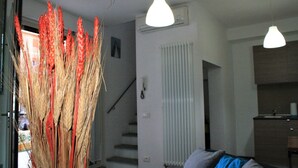 Un intérieur moderne avec un escalier, un radiateur et un coin cuisine.